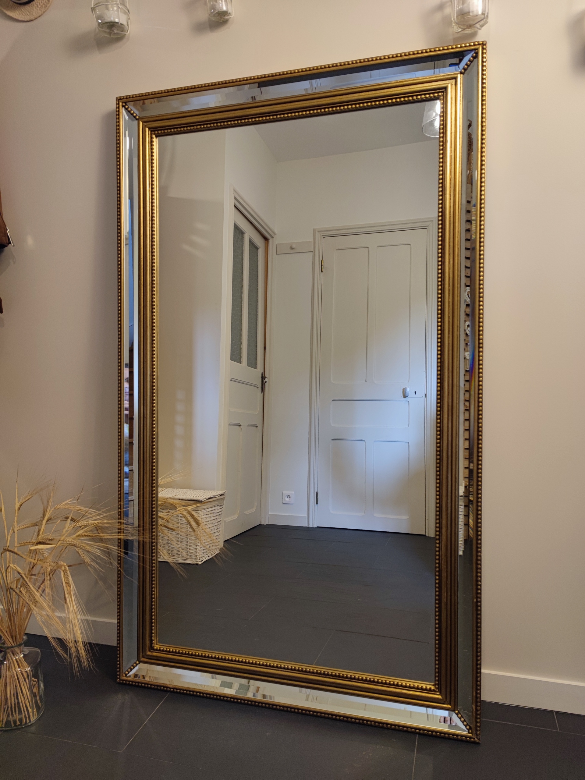 Ancien miroir de cheminée dont il ne restait plus que le cadre, "Jade" est devenu un beau miroir en pied. Son cadre doré patiné et sa petite bande de miroir au centre des dorures lui confèrent un look peu commun.