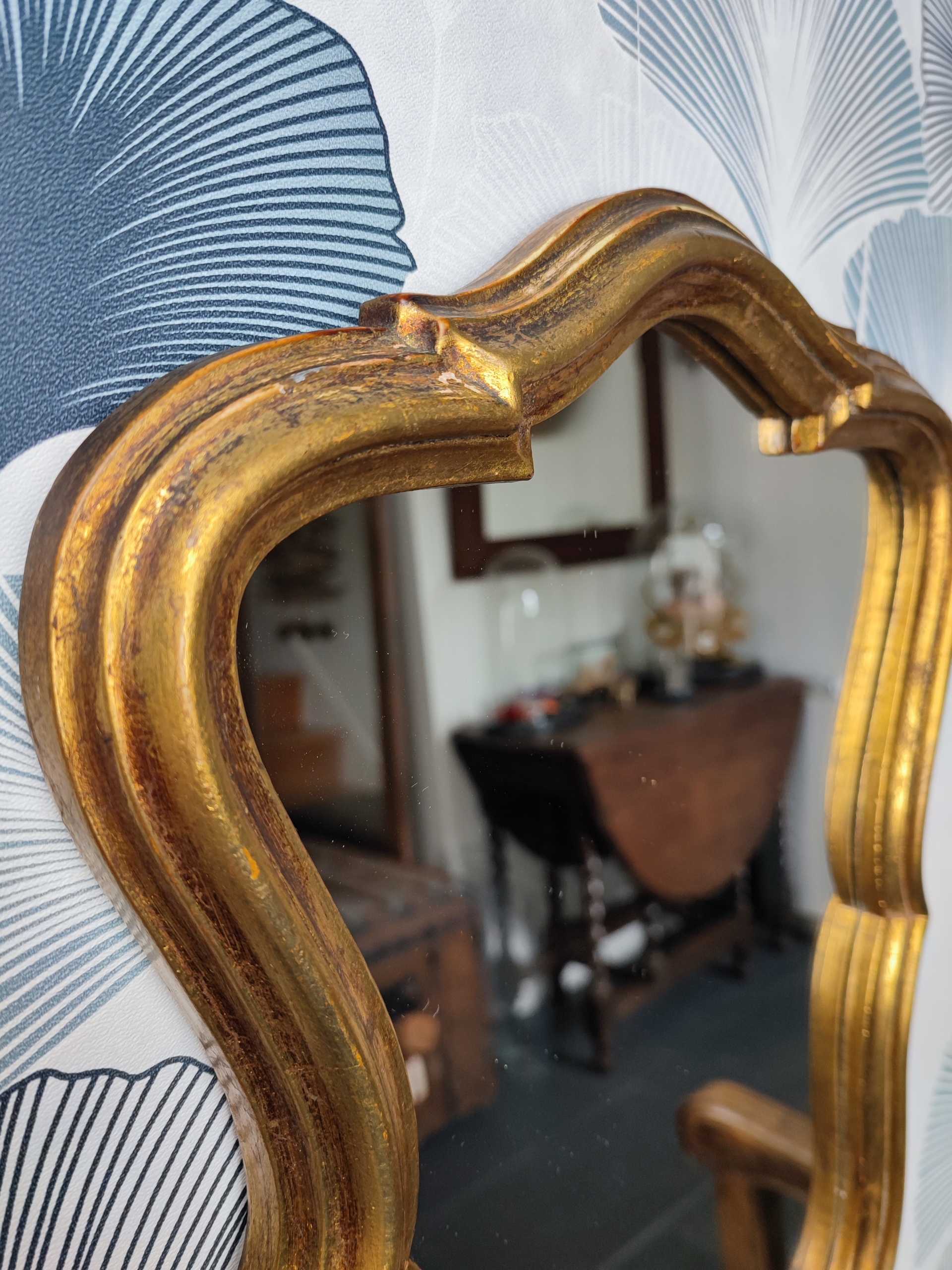 Zoom sur un petite miroir baroque "Antoinette" ancien, en plâtre mouluré finition doré patiné.