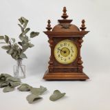Ancienne horloge "Apolline" à poser de type Junghans datant de 1946. Carillon, boite à musique pouvant servir de réveil. Boitier en bois mouluré et à colonnettes dans les angles. Bronzes dans les angles du cadran doré ainsi que sur le fronton.