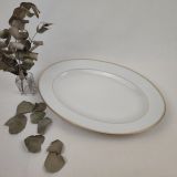 Plan ovale en porcelaine de Limoges "Lafarge", assortie au modèle Blin-A. Filet doré épais souligné d'un plus fin sur le bord de l'assiette et 1 filet fin en pourtour du centre. Possibilité de le compléter avec les assiettes plates, l'assiette creuse et les assiettes à dessert du même modèle également disponibles.