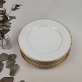 Ensemble de 6 assiettes plates en porcelaine de Limoges blanches et décorées d'un filet doré épais surligné d'un plus fin en pourtour de l'assiette.