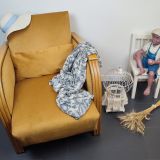 Entre lignes géométriques et chaleur du bois, André(e) incarne toute l’élégance du style Art déco. Entièrement rénové, ce fauteuil des années 1920 retrouve son éclat d’origine tout en adoptant une touche contemporaine. La structure en hêtre massif a été soigneusement poncée, traitée et éclaircie avant d’être protégée par un verni à la teinte chêne doré satiné, pour s'accorder au mieux aux fauteuils existants des clients. L’assise et le dossier ont été refaits selon les techniques traditionnelles et recouverts d’un velours miel profond, doux et lumineux, qui met en valeur la finesse des accoudoirs galbés et les détails d’époque. Chaque finition est le fruit d’un travail patient et exigeant : les coutures, invisibles, sont réalisées à la main, dans le respect du fauteuil et de son époque. Son dossier basculant offre un confort supplémentaire, parfait pour un moment de lecture ou de détente. 