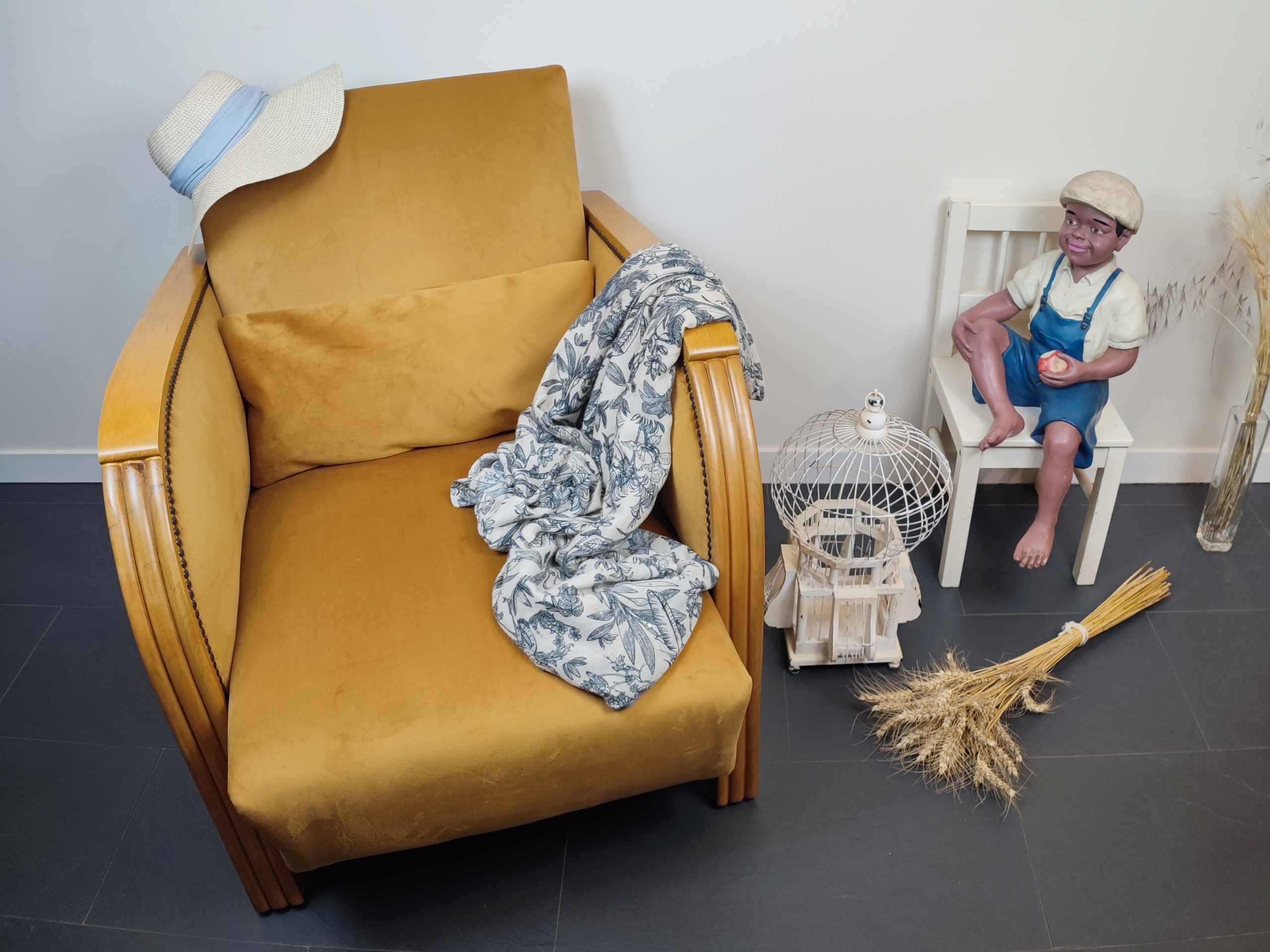 Entre lignes géométriques et chaleur du bois, André(e) incarne toute l’élégance du style Art déco. Entièrement rénové, ce fauteuil des années 1920 retrouve son éclat d’origine tout en adoptant une touche contemporaine. La structure en hêtre massif a été soigneusement poncée, traitée et éclaircie avant d’être protégée par un verni à la teinte chêne doré satiné, pour s'accorder au mieux aux fauteuils existants des clients. L’assise et le dossier ont été refaits selon les techniques traditionnelles et recouverts d’un velours miel profond, doux et lumineux, qui met en valeur la finesse des accoudoirs galbés et les détails d’époque. Chaque finition est le fruit d’un travail patient et exigeant : les coutures, invisibles, sont réalisées à la main, dans le respect du fauteuil et de son époque. Son dossier basculant offre un confort supplémentaire, parfait pour un moment de lecture ou de détente.