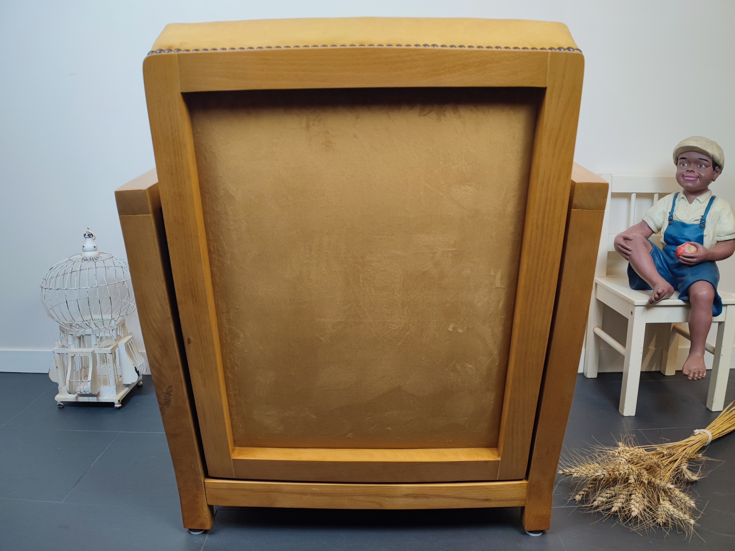 Entre lignes géométriques et chaleur du bois, André(e) incarne toute l’élégance du style Art déco. Entièrement rénové, ce fauteuil des années 1920 retrouve son éclat d’origine tout en adoptant une touche contemporaine. La structure en hêtre massif a été soigneusement poncée, traitée et éclaircie avant d’être protégée par un verni à la teinte chêne doré satiné, pour s'accorder au mieux aux fauteuils existants des clients. L’assise et le dossier ont été refaits selon les techniques traditionnelles et recouverts d’un velours miel profond, doux et lumineux, qui met en valeur la finesse des accoudoirs galbés et les détails d’époque. Chaque finition est le fruit d’un travail patient et exigeant : les coutures, invisibles, sont réalisées à la main, dans le respect du fauteuil et de son époque. Son dossier basculant offre un confort supplémentaire, parfait pour un moment de lecture ou de détente.